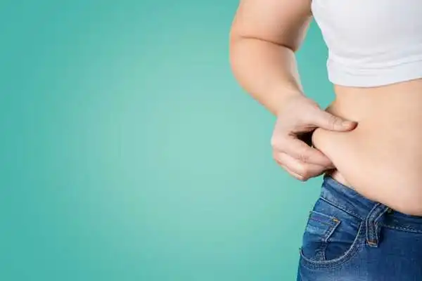 Image of woman pinching her love handles to show weight gain Bishopbriggs